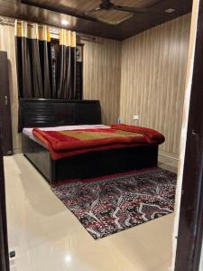 a bedroom with a bed with a rug on the floor at new Subh Apartment in Bhowāli