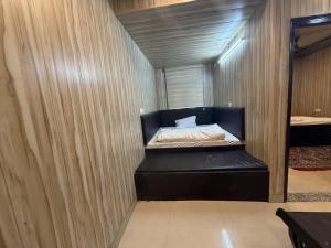 a bedroom with a bed in a room with wooden walls at new Subh Apartment in Bhowāli