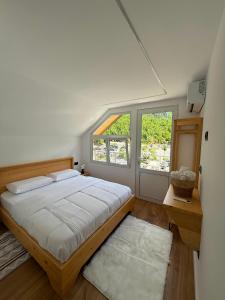 a bedroom with a large bed and a window at Guesthouse Kurora e Maleve in Ndërlysaj