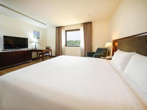 a hotel room with a large bed and a television at CHECK inn Taipei Neihu in Taipei +64 photos