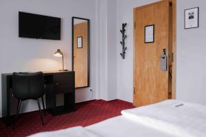 a bedroom with a desk and a chair and a mirror at Landhaus Stümpelstal in Marburg an der Lahn