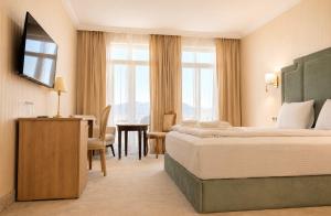 a hotel room with a large bed and a table at Aleksov Complex Sans Souci in Ognyanovo +28 photos
