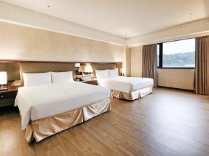 a hotel room with two beds and a large window at CHECK inn Taipei Neihu in Taipei