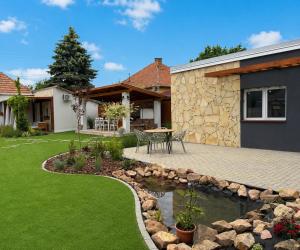 a garden with a patio and a pond at Monika Apartment in Bogács