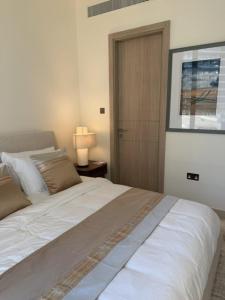 a bedroom with a large white bed and a door at Inter Home Coral - beach access in Ras al Khaimah +19 photos