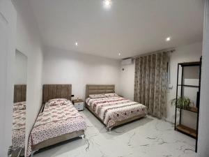 a bedroom with two beds and a window at Rent Room Albano in Vlorë