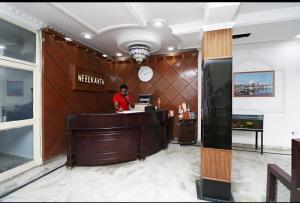 a man standing at a counter in a lobby at Hotel Neelkanth in Lucknow