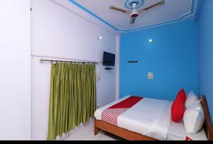 a bedroom with a bed and a green curtain at Hotel Neelkanth in Lucknow