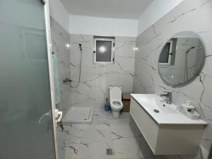 a bathroom with a sink and a toilet and a mirror at Rent Room Albano in Vlorë