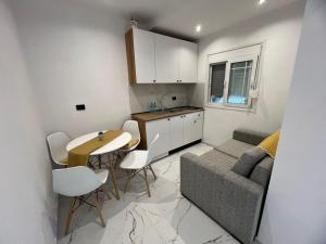 a kitchen and dining room with a table and a couch at Rent Room Albano in Vlorë