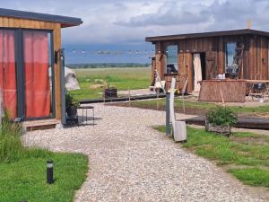 a couple of small wooden buildings in a field at Zeltarasa in Avotkalni