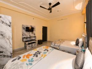 a bedroom with two beds and a tv at Bhagirathi Residency in Rishīkesh +7 photos
