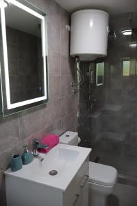 a bathroom with a sink and a toilet and a mirror at La Casa Di Martin in Ulcinj
