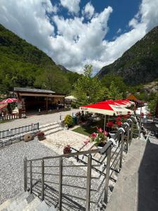 a resort with tables and umbrellas and a building at Guesthouse Kurora e Maleve in Ndërlysaj +13 photos
