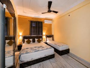 a bedroom with two beds and a ceiling fan at Bhagirathi Residency in Rishīkesh
