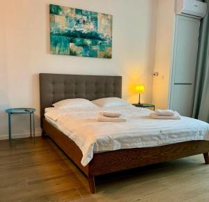 a bedroom with a large bed with two towels on it at MAYA Studio-Onix Blue with Private Parking, Mamaia Nord in Mamaia Sat/Năvodari
