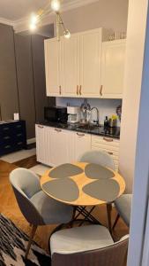 a kitchen with a table and chairs in a kitchen at My Mountain View - 50 m od Krupówek in Zakopane +8 photos