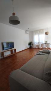 a living room with a couch and a table with chairs at Ca la Torreta in Torredembarra