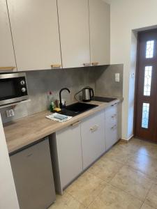 a kitchen with white cabinets and a sink at Agroturystyka na Górce in Nowa Wies