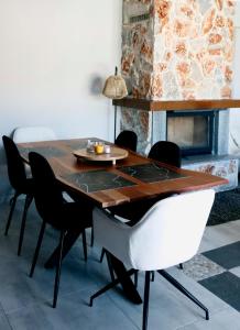 a dining room with a table and chairs and a fireplace at Mountain Aura - Stylish Escape in Kamarítsa