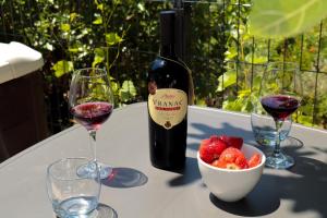 a bottle of wine and a bowl of strawberries on a table at La Casa Di Martin in Ulcinj