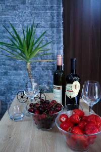 a table with two bottles of wine and bowls of fruit at La Casa Di Martin in Ulcinj +20 photos