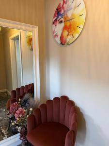 a waiting room with two chairs and a clock on the wall at GZP Residence Lugoj 13 in Lugoj