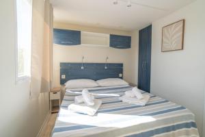 a bedroom with a bed with two towels on it at Agricamping L'Ibisco in Riotorto