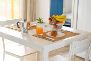 a table with a breakfast of orange juice and fruit at Agricamping L'Ibisco in Riotorto +44 photos