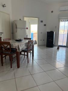 a kitchen and dining room with a table and chairs at Comfort Home in Capoterra +4 photos