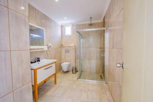 a bathroom with a shower and a sink and a toilet at La Moda Beach Hotel in Kaş