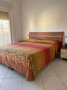 a large bed in a room with a window at Comfort Home in Capoterra