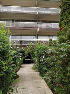 a walkway in front of a building with flowers at nys willy in Grimbergen