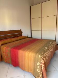 a bedroom with a bed with a colorful blanket at Comfort Home in Capoterra