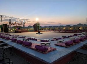 a group of tables with purple pillows on a patio at Jaisalmer Villa Resort & Camp Jaisalmer in Jaisalmer +215 photos