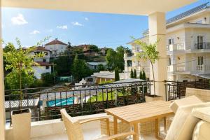 a balcony with a wooden table and chairs and a view at Aleksov Complex Sans Souci in Ognyanovo