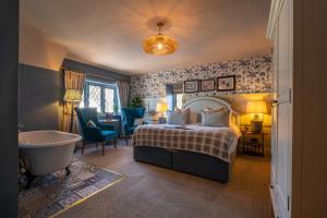 a bedroom with a bed and a bathtub and a bed and a bath tub at The Mayflower in Lymington