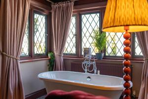 a bathroom with a tub in a room with windows at The Mayflower in Lymington +109 photos