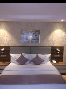a bedroom with a large bed with pillows at CARITAS HOTEL AND suite in Araromi