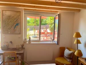 a room with a desk and a window with a view of a patio at Gîtes du Fort in Collonges