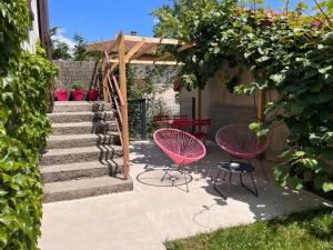 a patio with two pink chairs and a set of stairs at Gîtes du Fort in Collonges