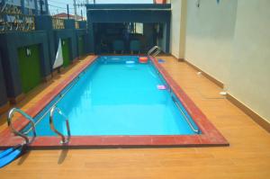 a large swimming pool in a room with a wooden floor at CARITAS HOTEL AND suite in Araromi