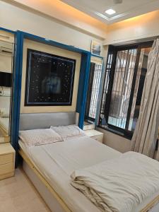 a bedroom with a bed and two windows at Meenaji's home in Mumbai