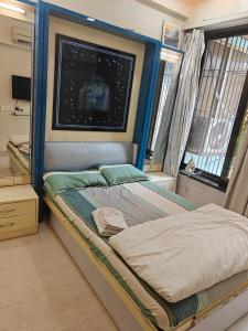 a bedroom with a bed in a room with a window at Meenaji's home in Mumbai