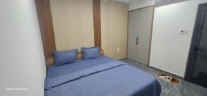 a blue bed with blue pillows in a bedroom at COMIC 2 Homestay in Danang