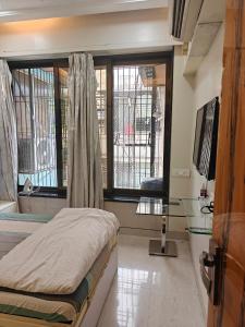 a bedroom with a bed and a window at Meenaji's home in Mumbai +3 photos