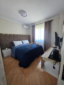 a bedroom with a bed and a desk with a television at Asea Apartaments in Golem