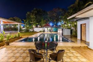 a patio with a table and chairs in front of a pool at Mountview Resort in Lonavala +35 photos