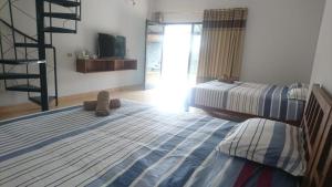 a bedroom with two twin beds and a television at Omah Laut Bondo Jepara - by the beach, direct view of the sea, great base for water sports in Margokerto