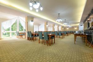 a dining room with a long table and chairs at Hotel Empire Europe in Prievidza